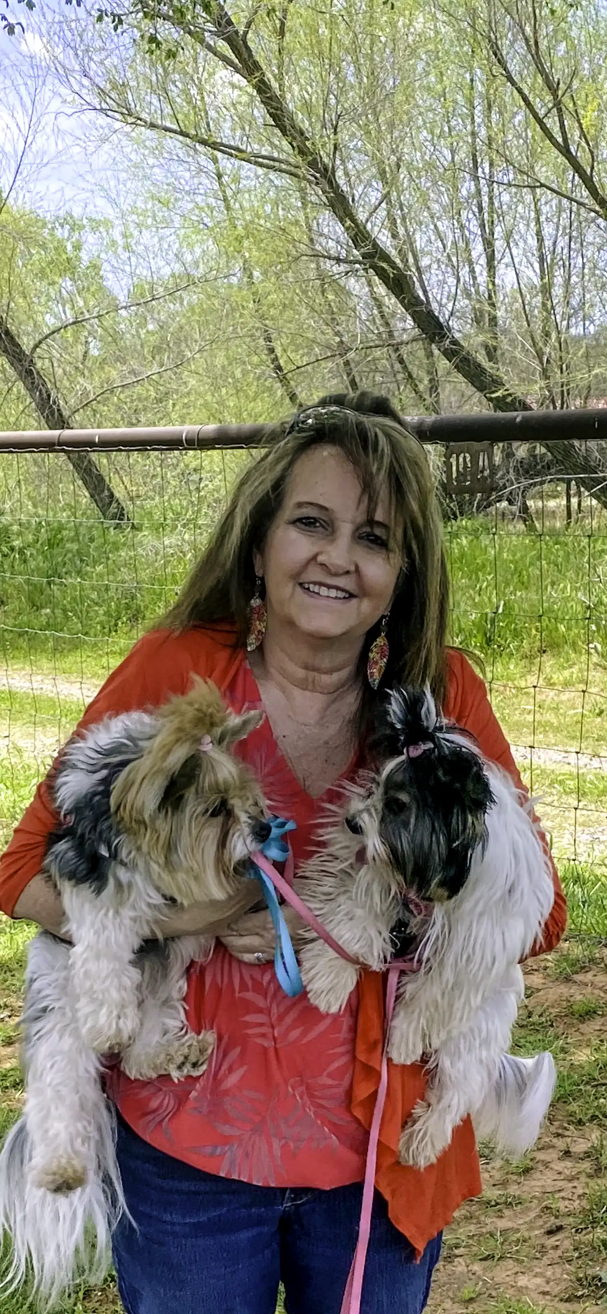 Tina, owner of Dainty Dog Spa, holding her two biewer terriers outdoors